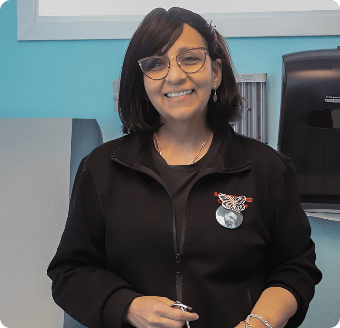 Smiling woman wearing glasses and black jacket.