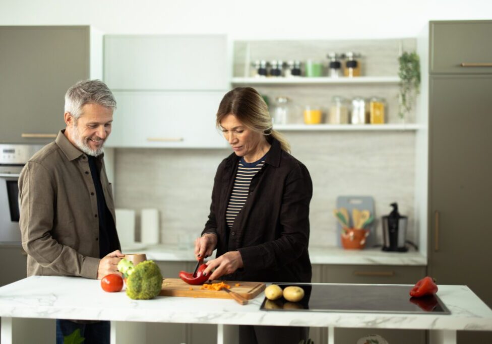 Couple preparing vegetables in modern kitchen.