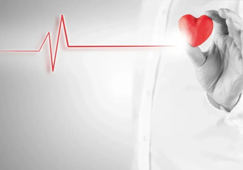 Hand holding heart with heartbeat line.
